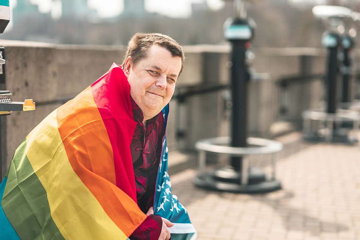 LGBTQ+ man sitting outside